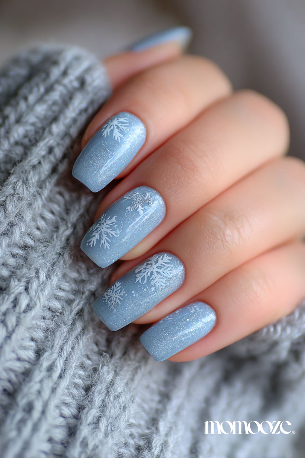 Blue nails with snowflake designs.