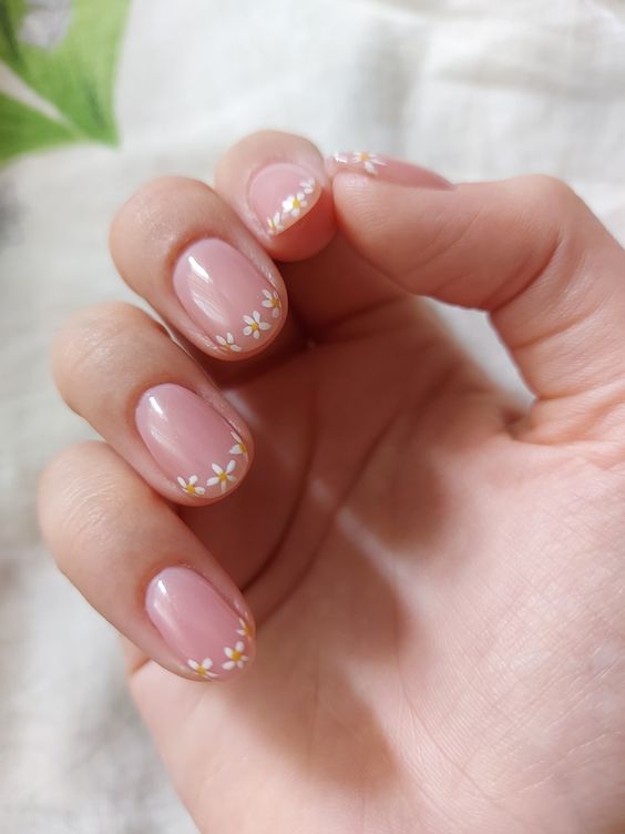 Short nails with floral French tips, featuring delicate daisies perfect for spring nail art and feminine styles.