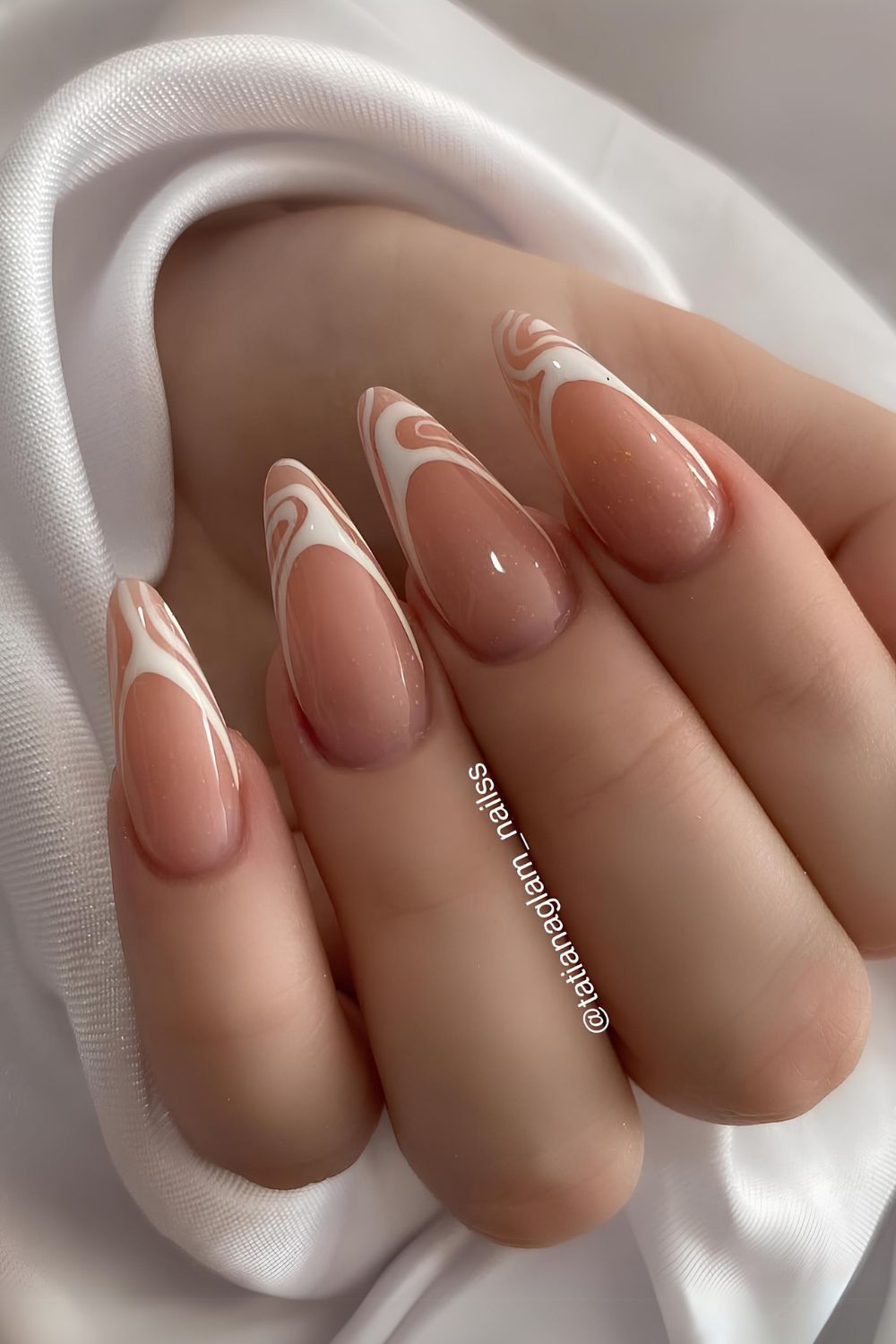 Long almond-shaped nails with swirled French tips, elegant and unique.