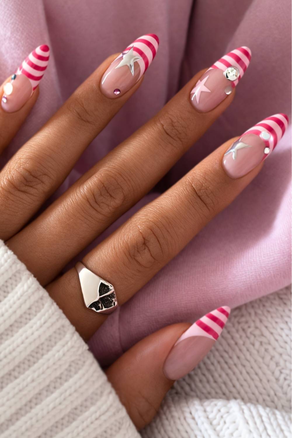 Candy cane striped nails with stars and jewels, playful and festive.