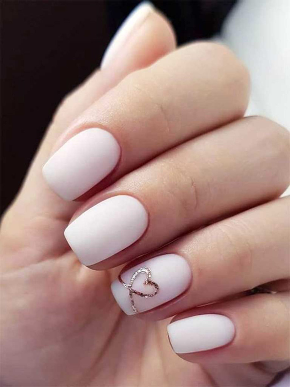 Matte white nails with heart accent, classic and chic.