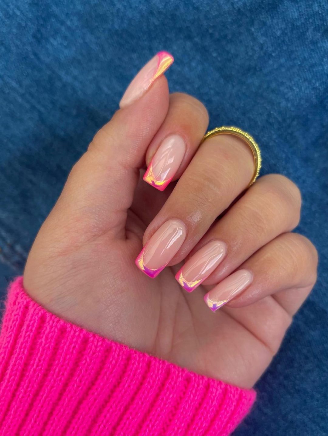 Neon French tips with a nude base, vibrant and playful.