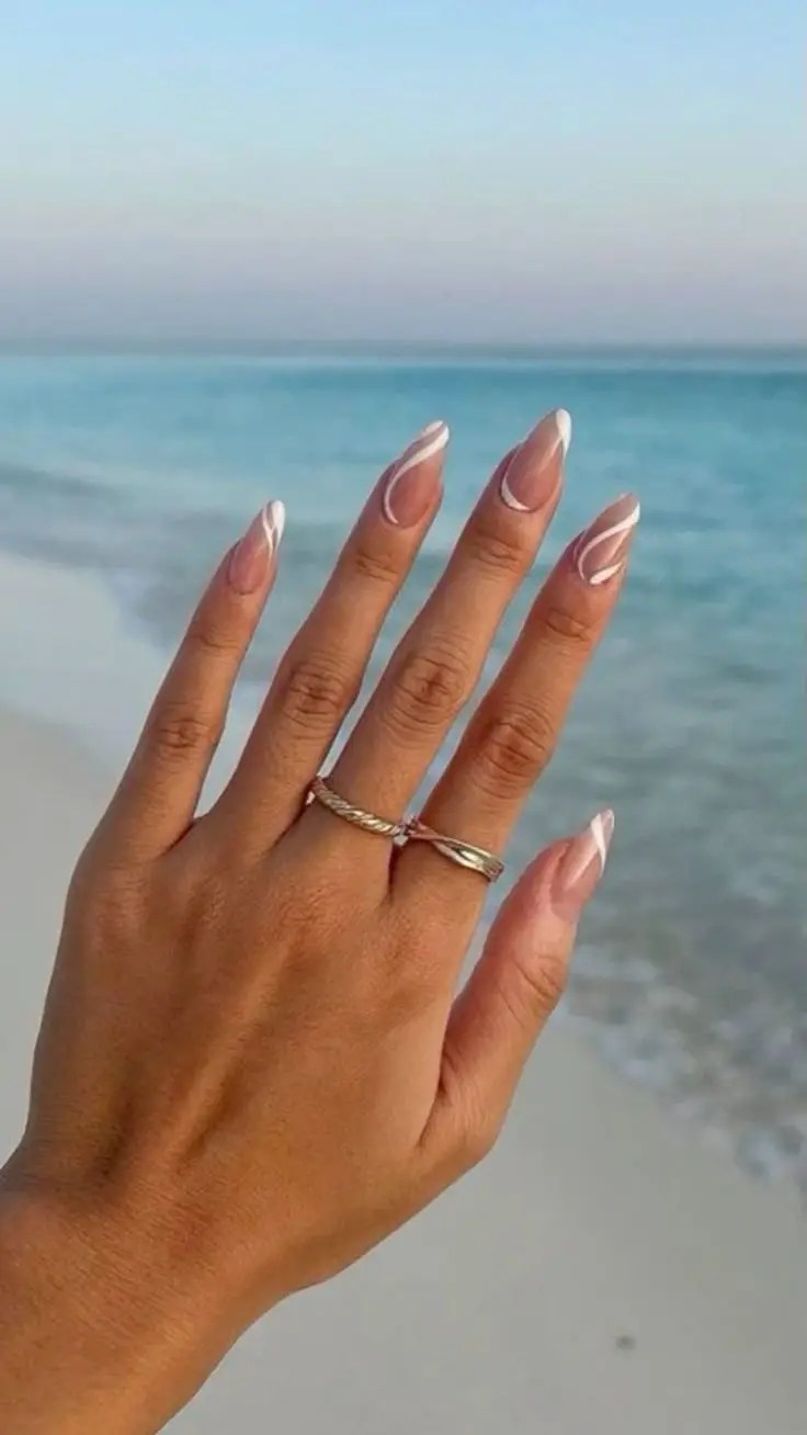 Coastal-inspired French tips with thin white lines on nude base, capturing beach vibes
