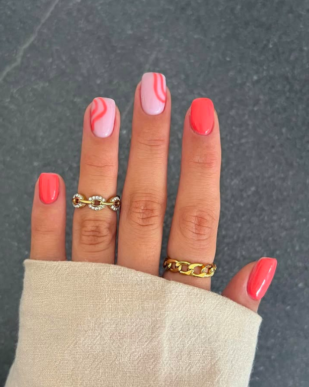 Coral and pink swirl nail art on square nails, embodying playful summer vibes