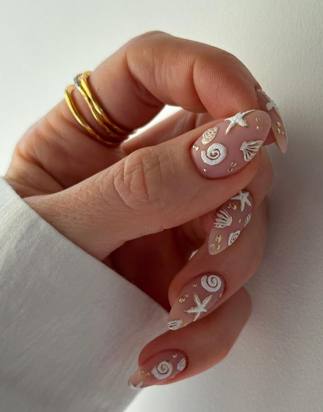 Seashell and starfish nail art on a nude base