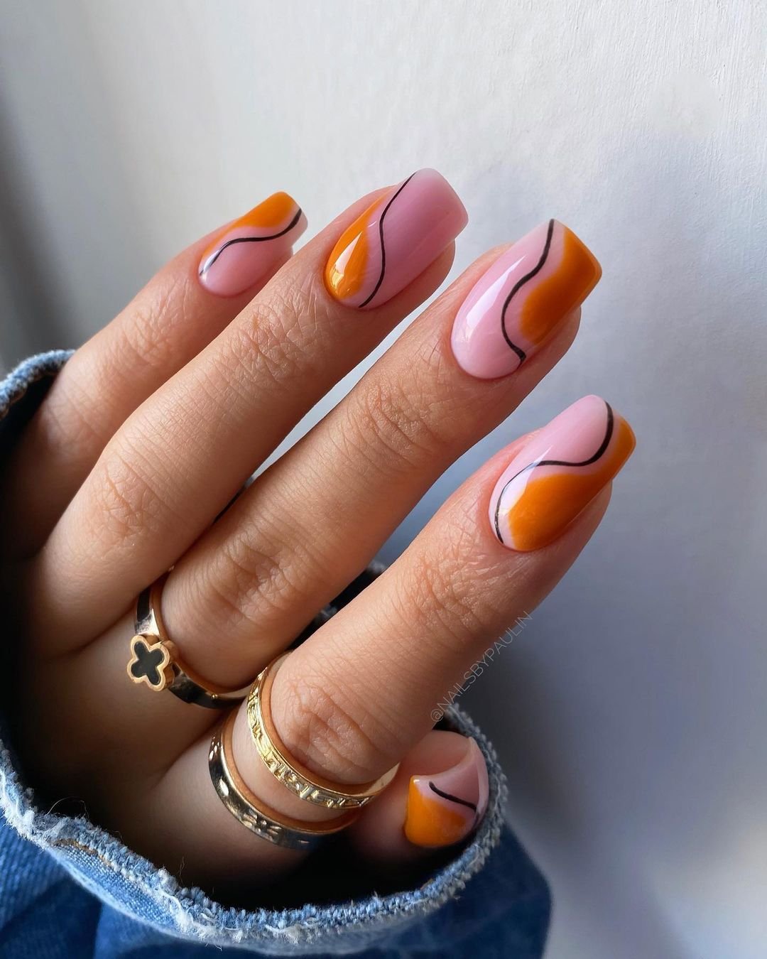 Orange and pink swirl nail art with a bold design