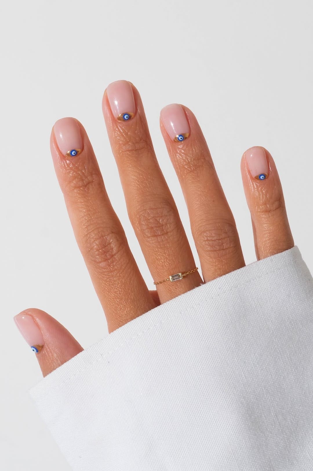 Nude nails with minimalist blue dot accents