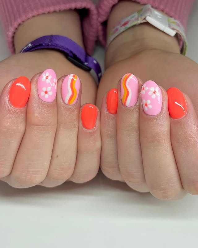 Floral and swirl designs on pink and orange nails