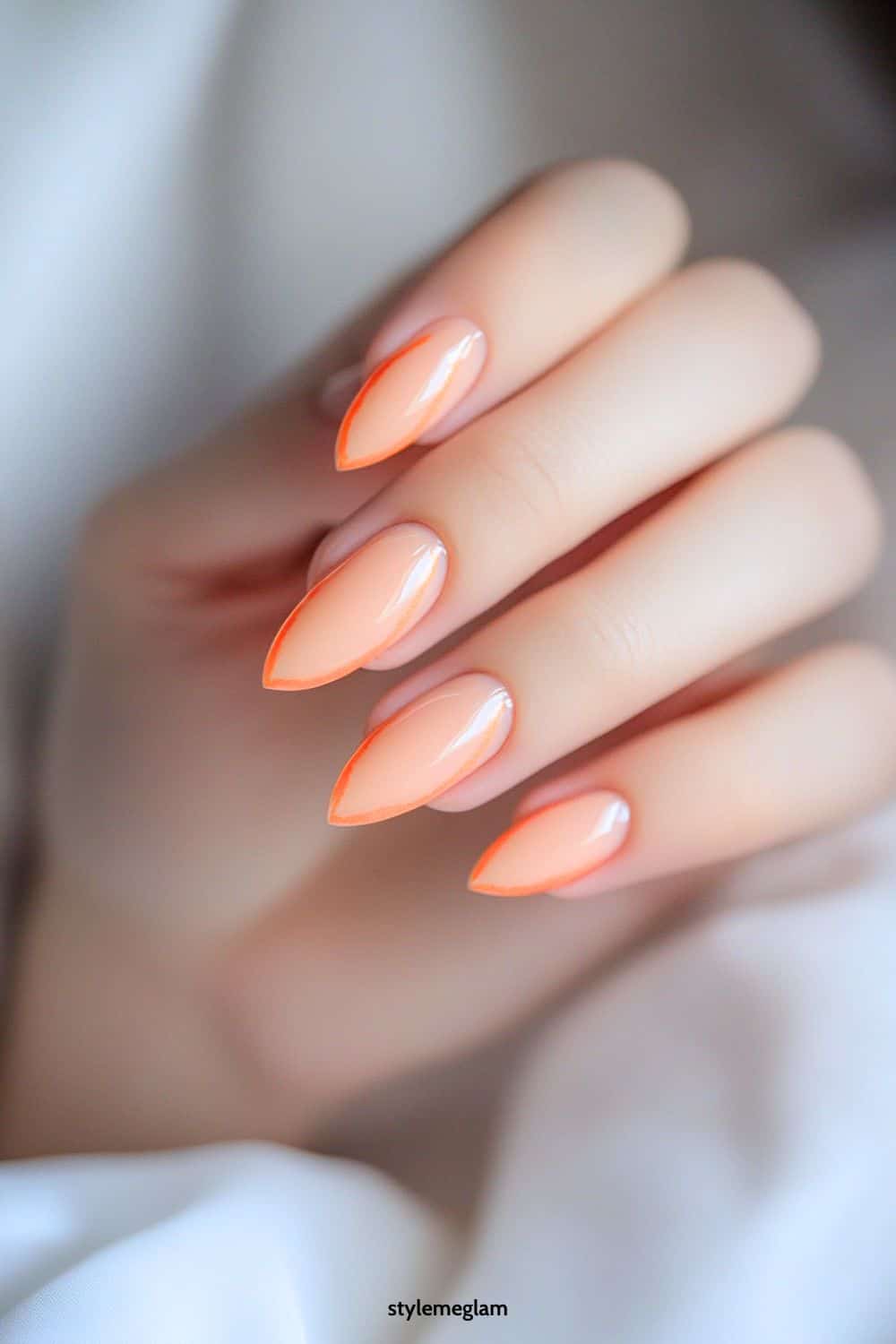 Neon peach almond nails with a glossy finish