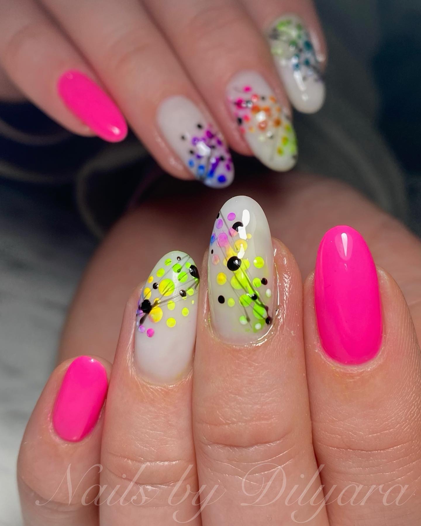 Colorful splatter art nails with hot pink accent