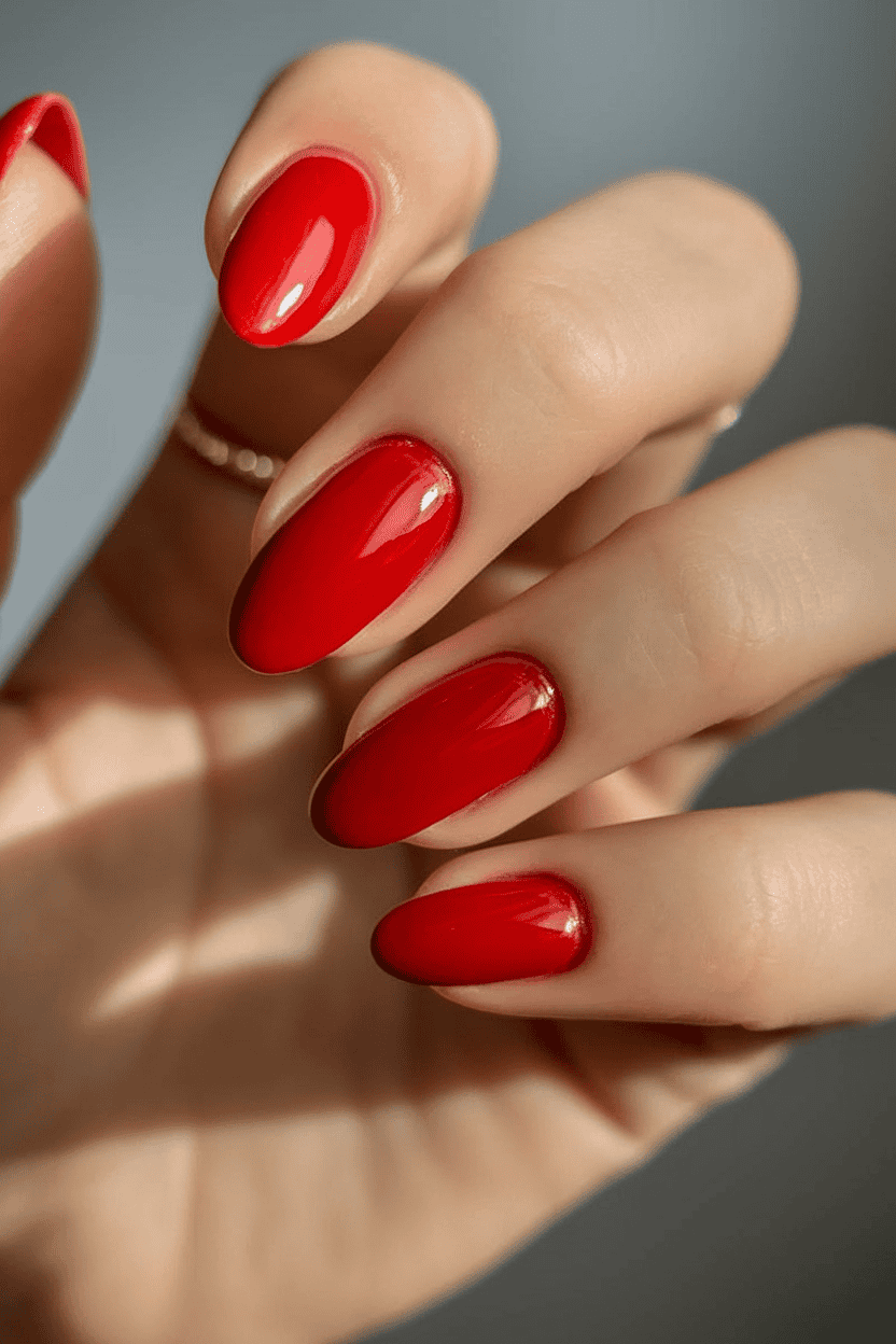 Vibrant red nails with a glossy finish, embodying timeless elegance and modern flair.