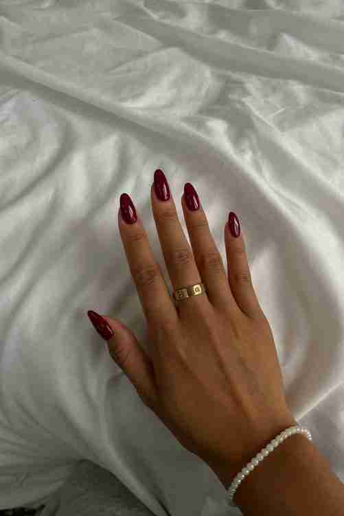 Deep crimson nails, glossy finish, timeless elegance.