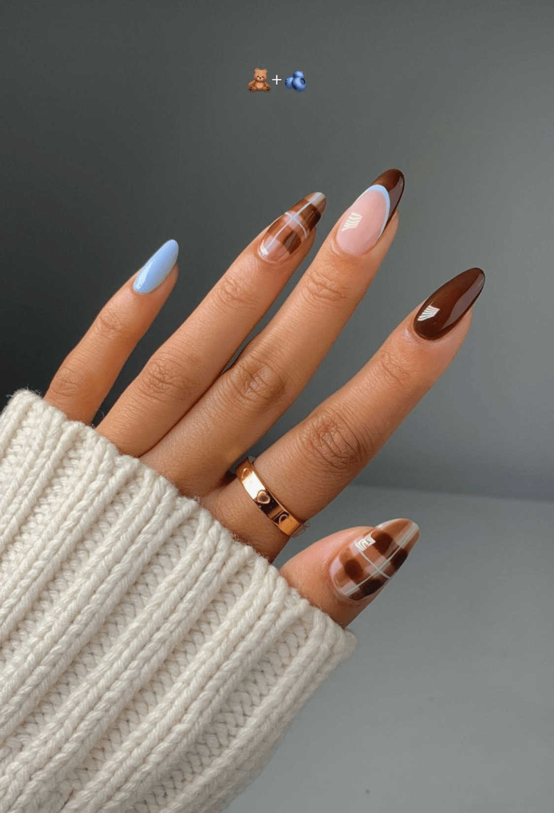 Artistic brown and blue swirl nails, creative flair.