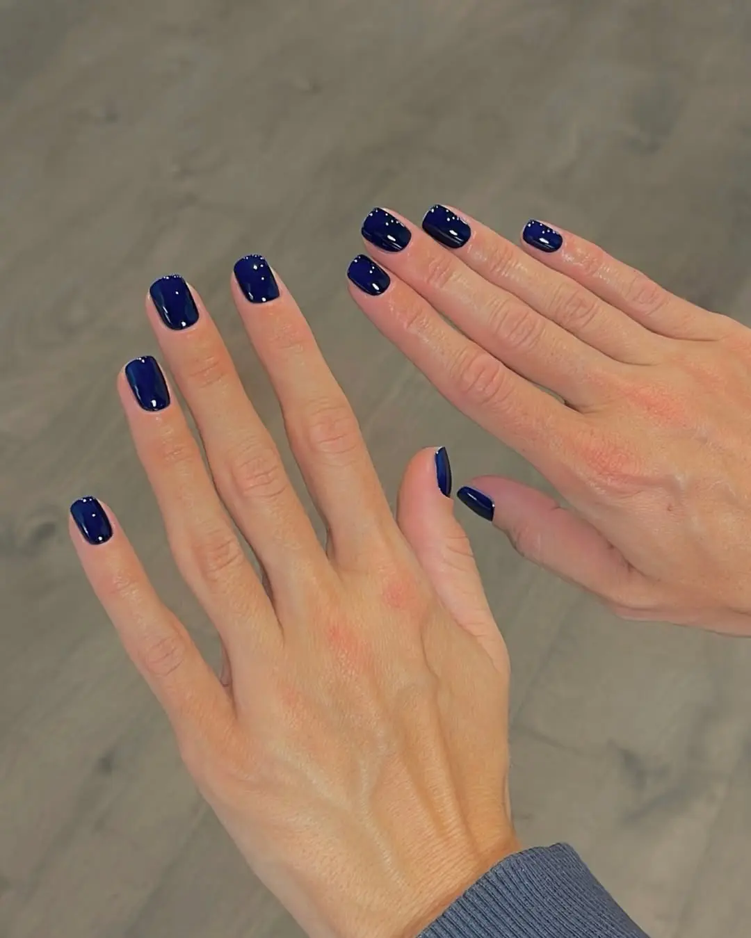 Classic navy nails, glossy finish, short oval shape.