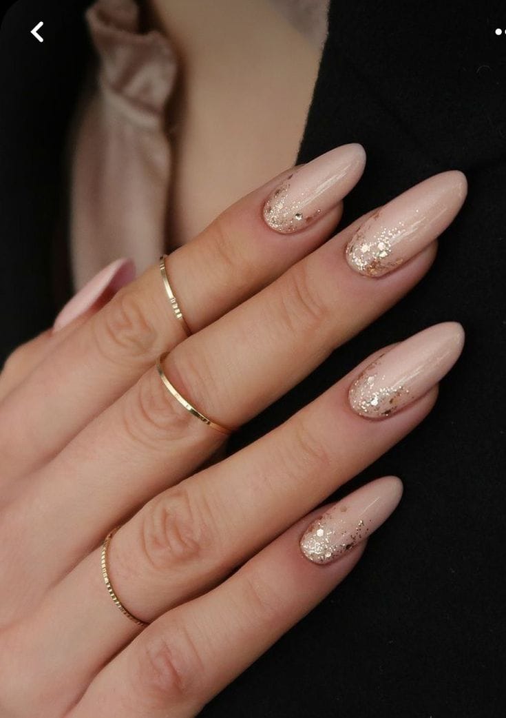 Soft pink nails with glitter accents, elegant sparkle.