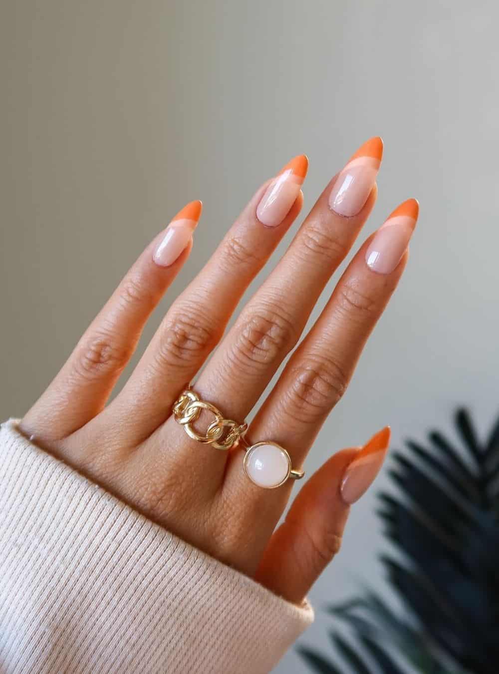 Orange French tip nails with gold jewelry