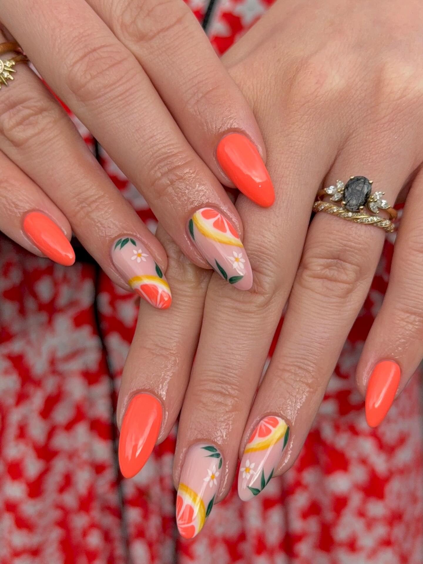 Orange nails with fruit designs and detailing