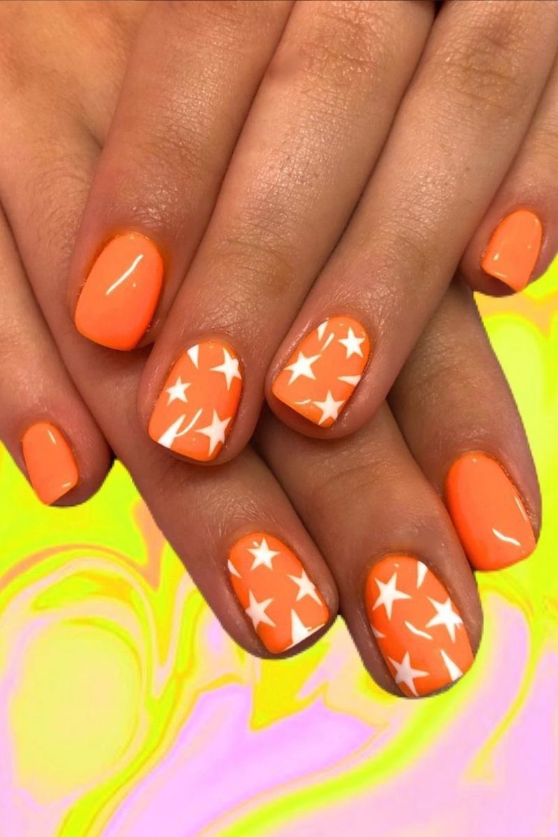 Orange nails with white star design