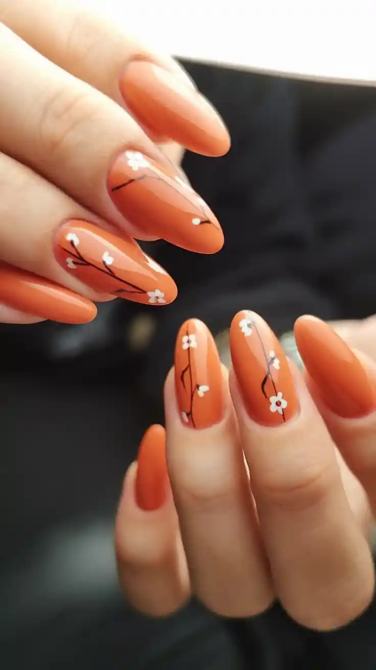 Matte orange nails with floral design