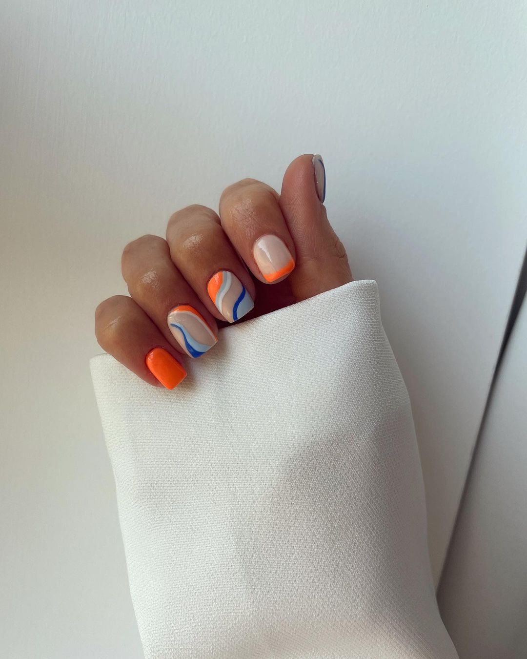 Short nails with orange and blue accents