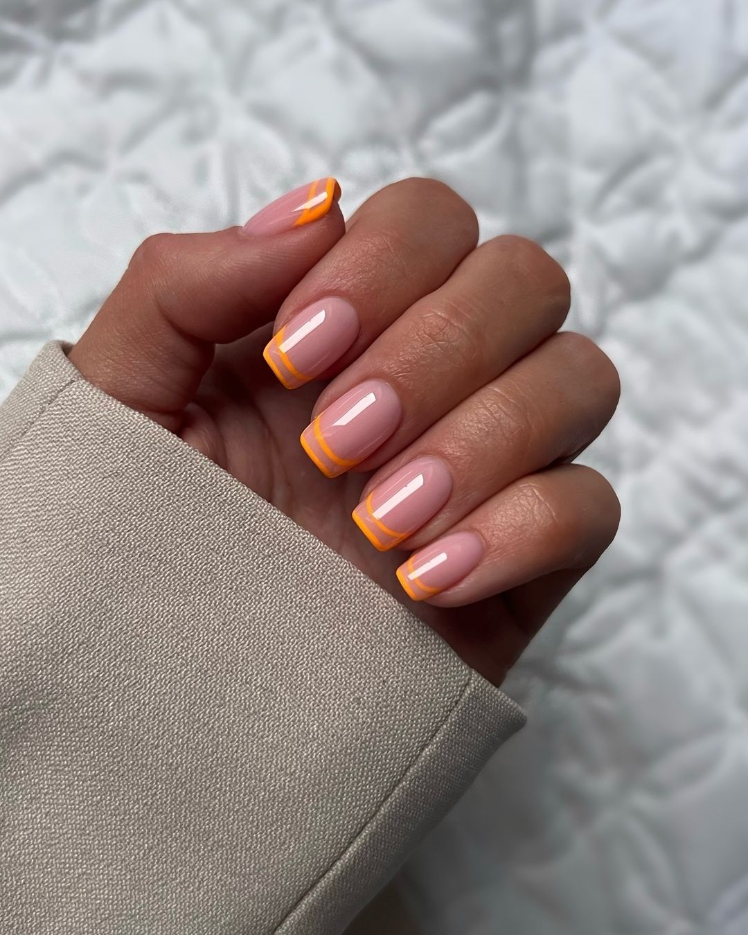 Nude nails with orange French tips