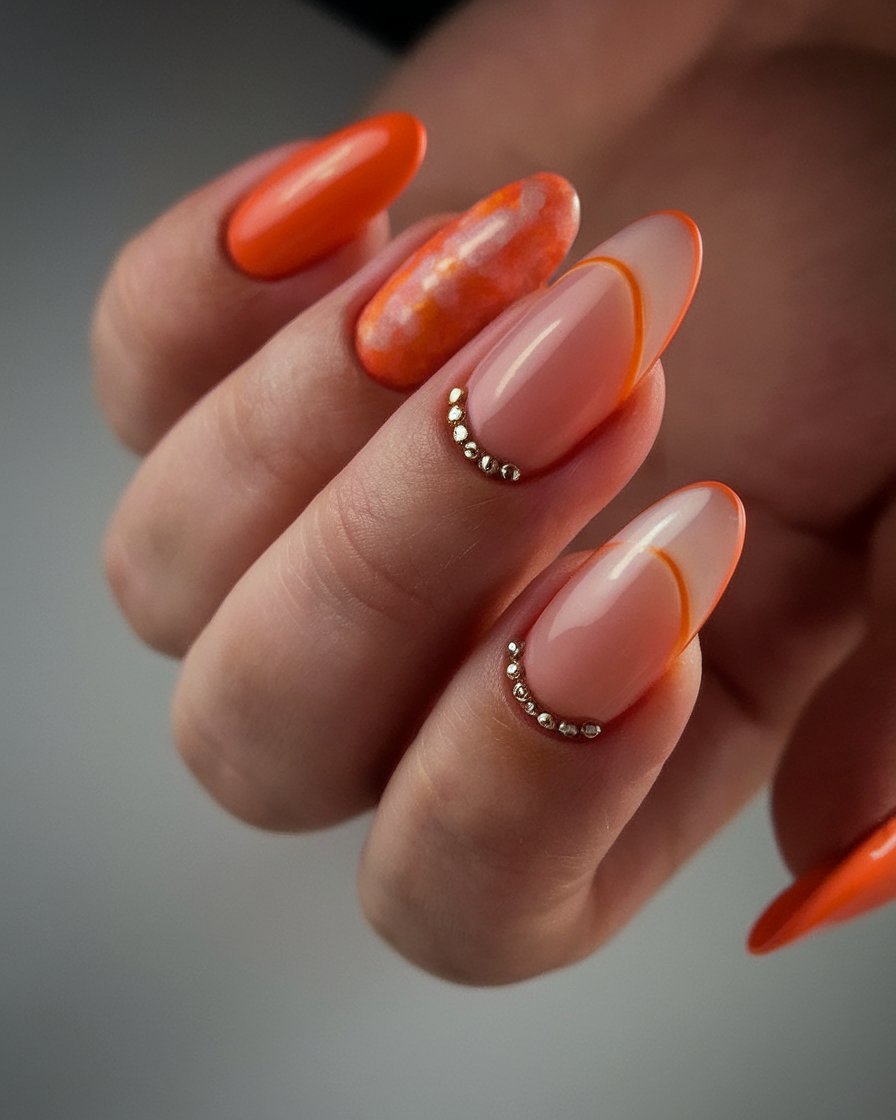 Medium almond nails with orange ombre and jewels
