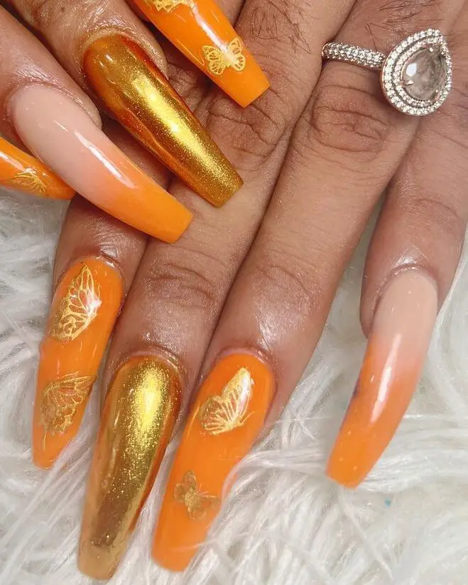 Orange and gold nails with butterfly accents