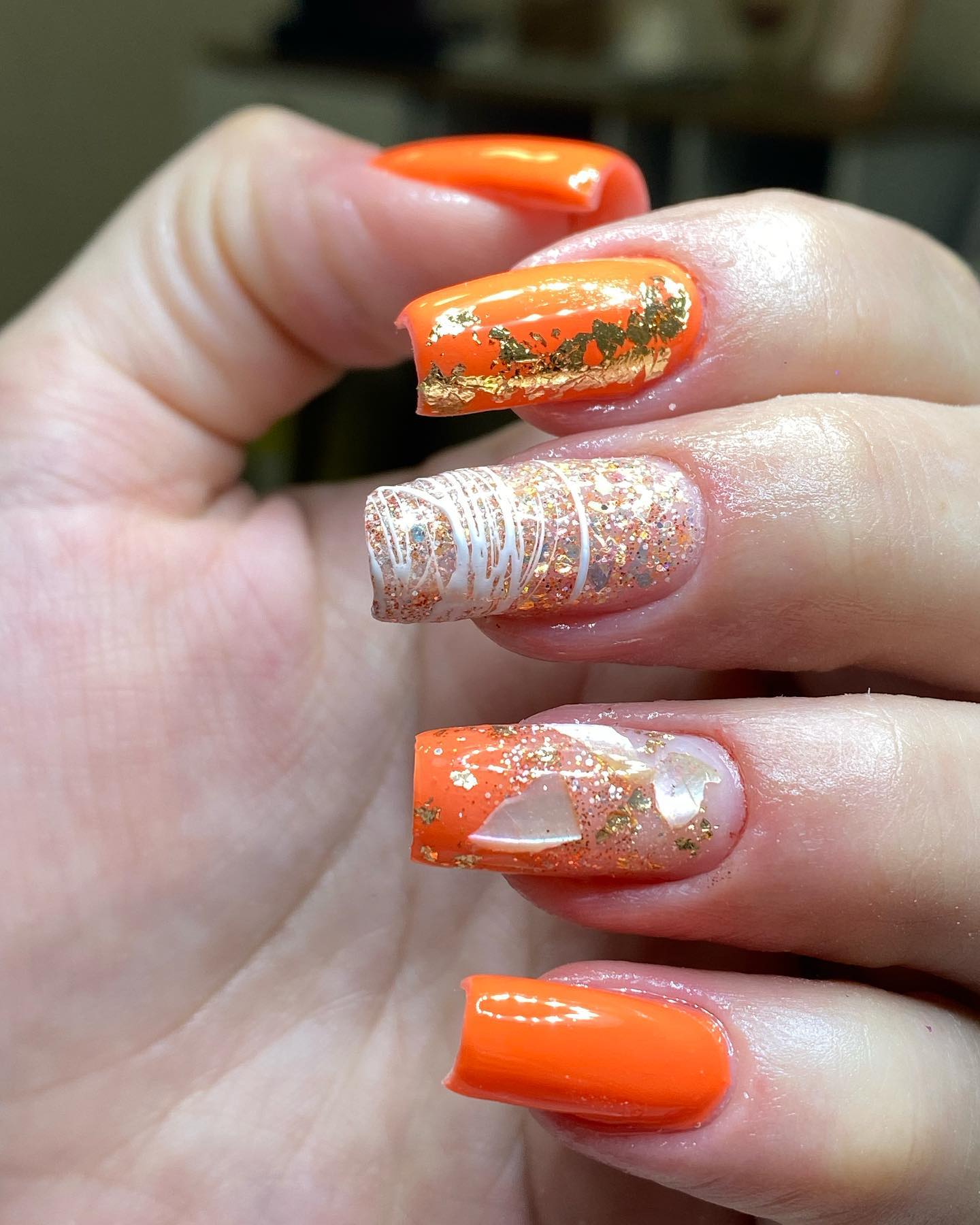 Orange nails with gold foil accents