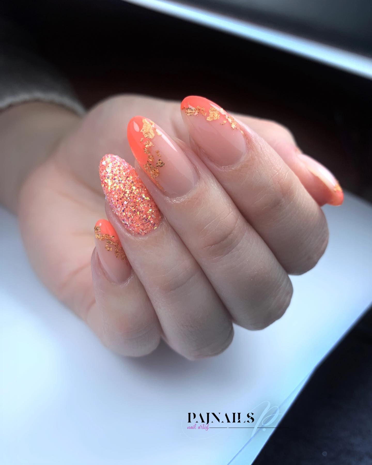 Glittery orange nails with almond shape