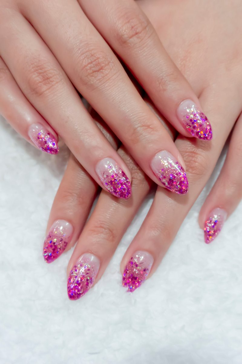 Short almond nails with vivid glitter tips, bold design