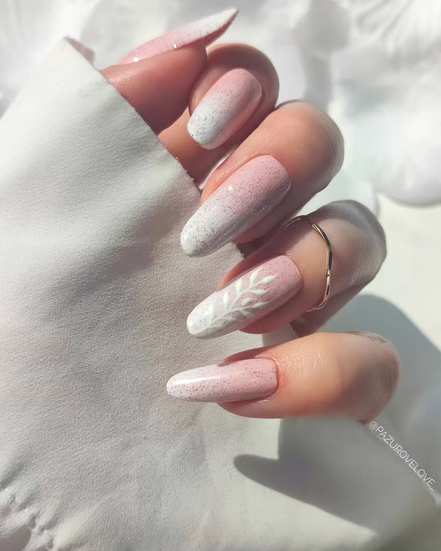 Leafy detail on pink ombre nails, elegant touch