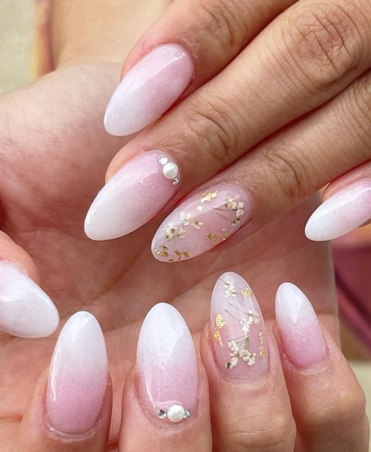 Almond pink ombre nails with floral accents, delicate design