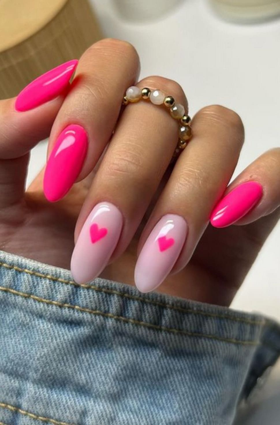 Bright pink nails with heart accents and Pinterest inspiration.