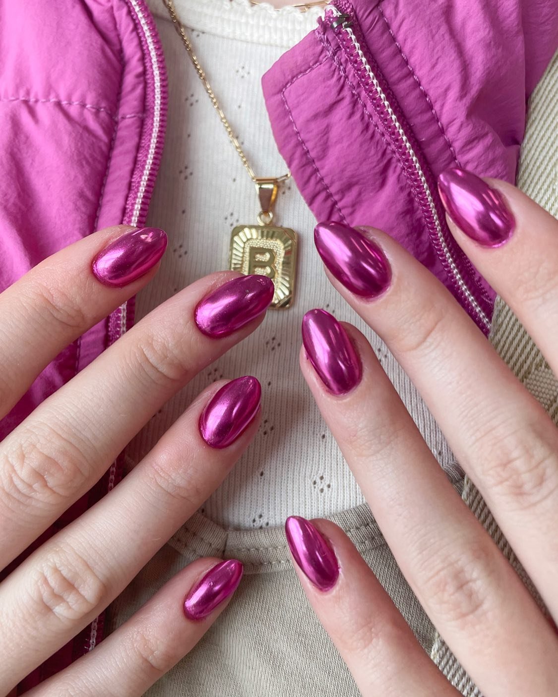 Metallic pink chrome nails reflecting light and Pinterest trends.