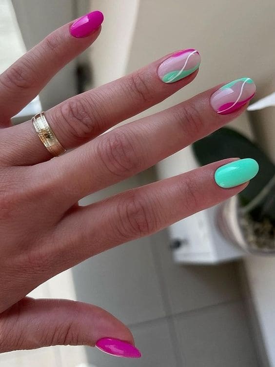 Bold pink and green swirl nail art with a glossy finish.