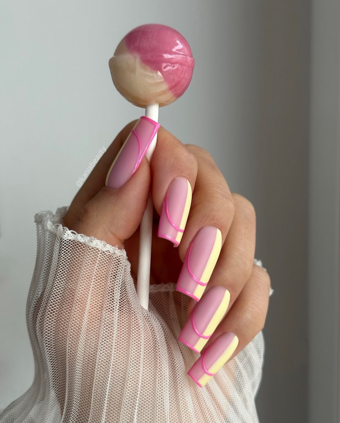 Pastel candy stripe nails with pink and yellow accents.