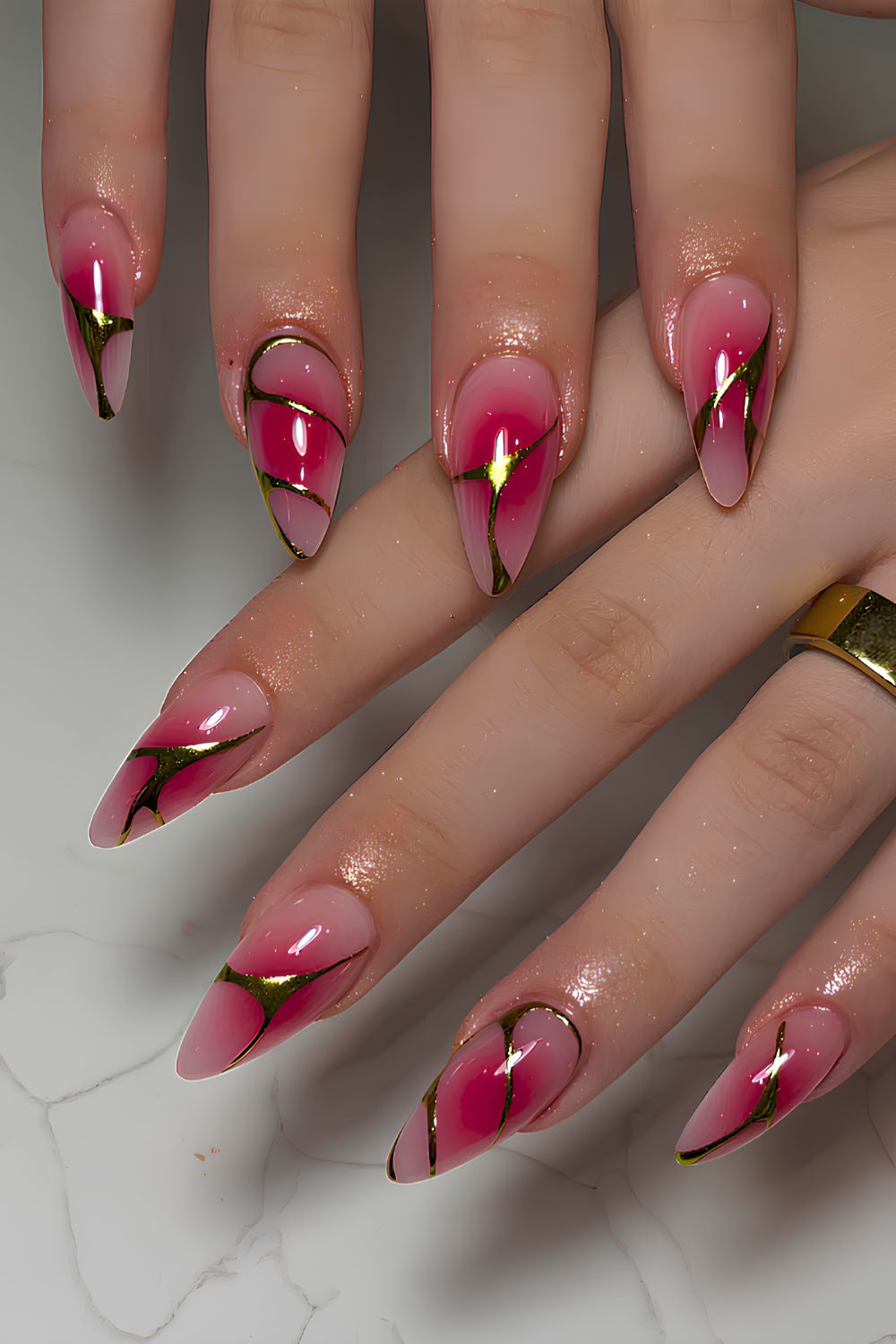 Pink and gold swirl stiletto nails.