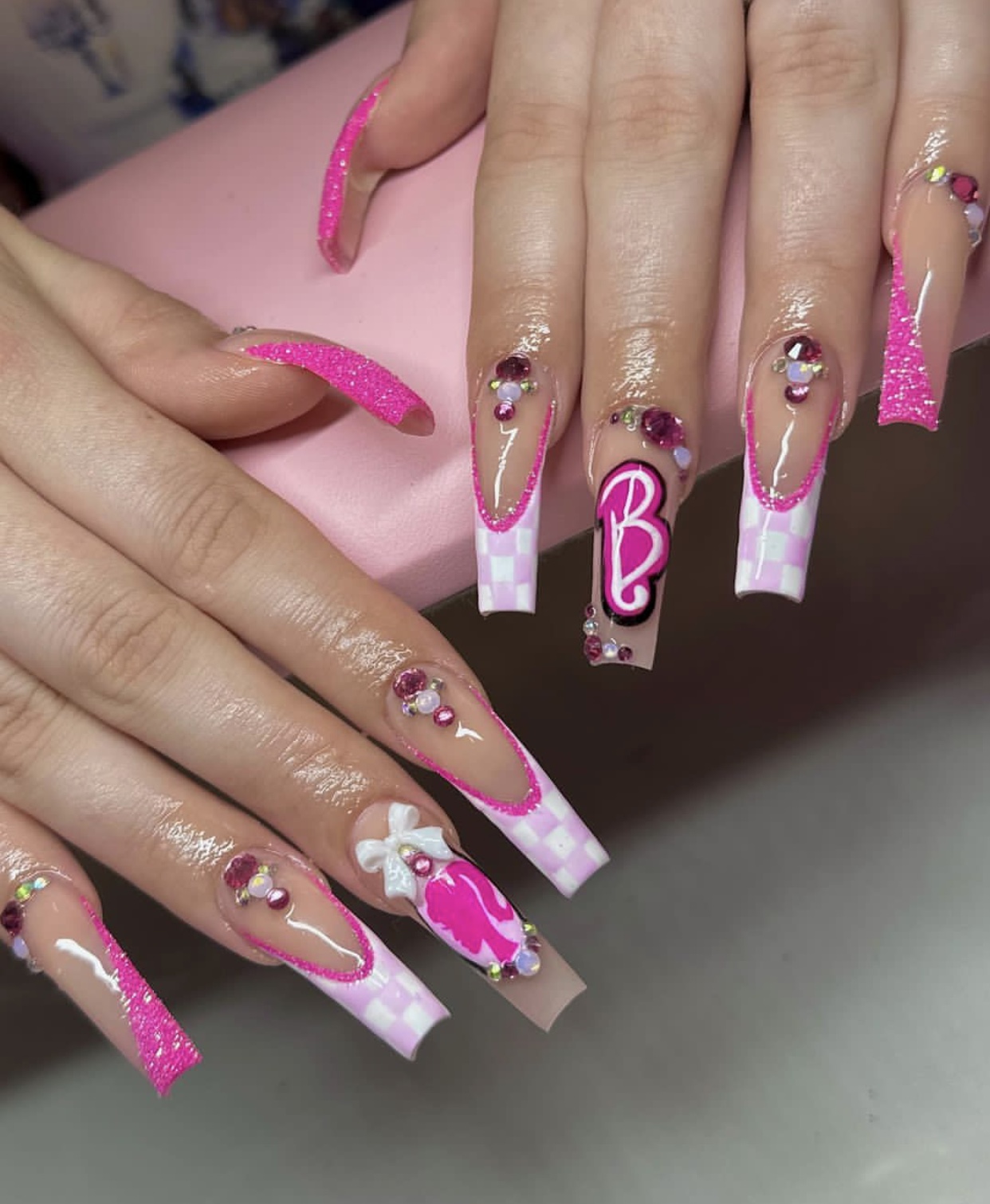 Barbie pink nails with glam accents and coffin shape.