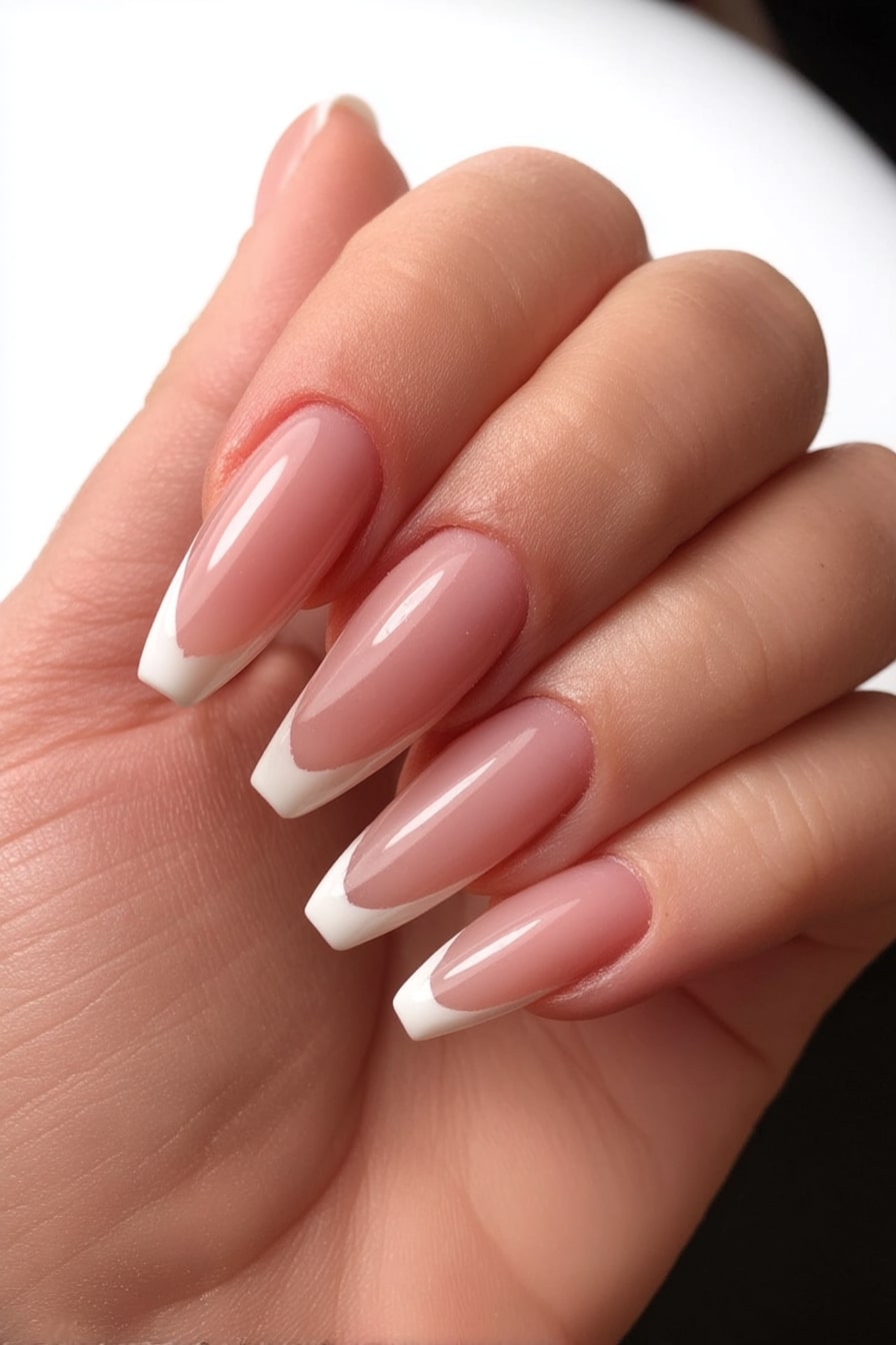 Classic white French tips on long almond nails.