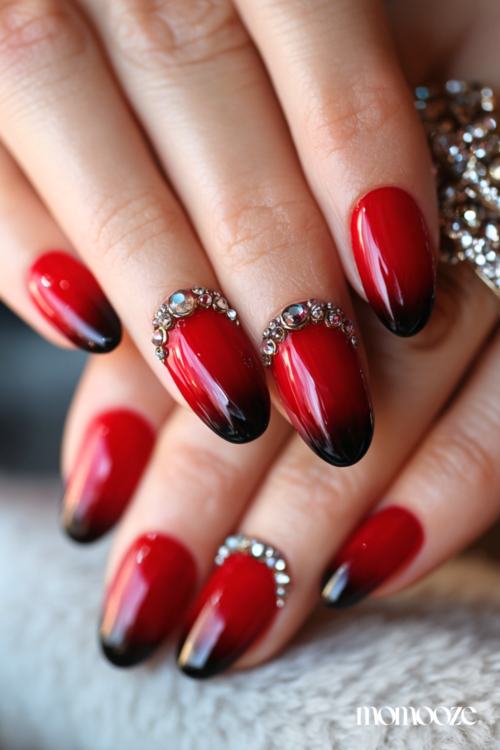 Red gemmed French tips on oval nails.