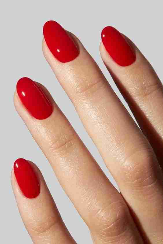 Classic red polish on short oval nails.