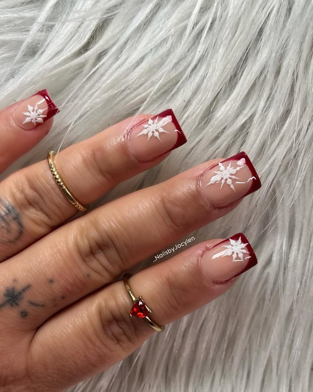 Red nails with snowflake accents and square shape