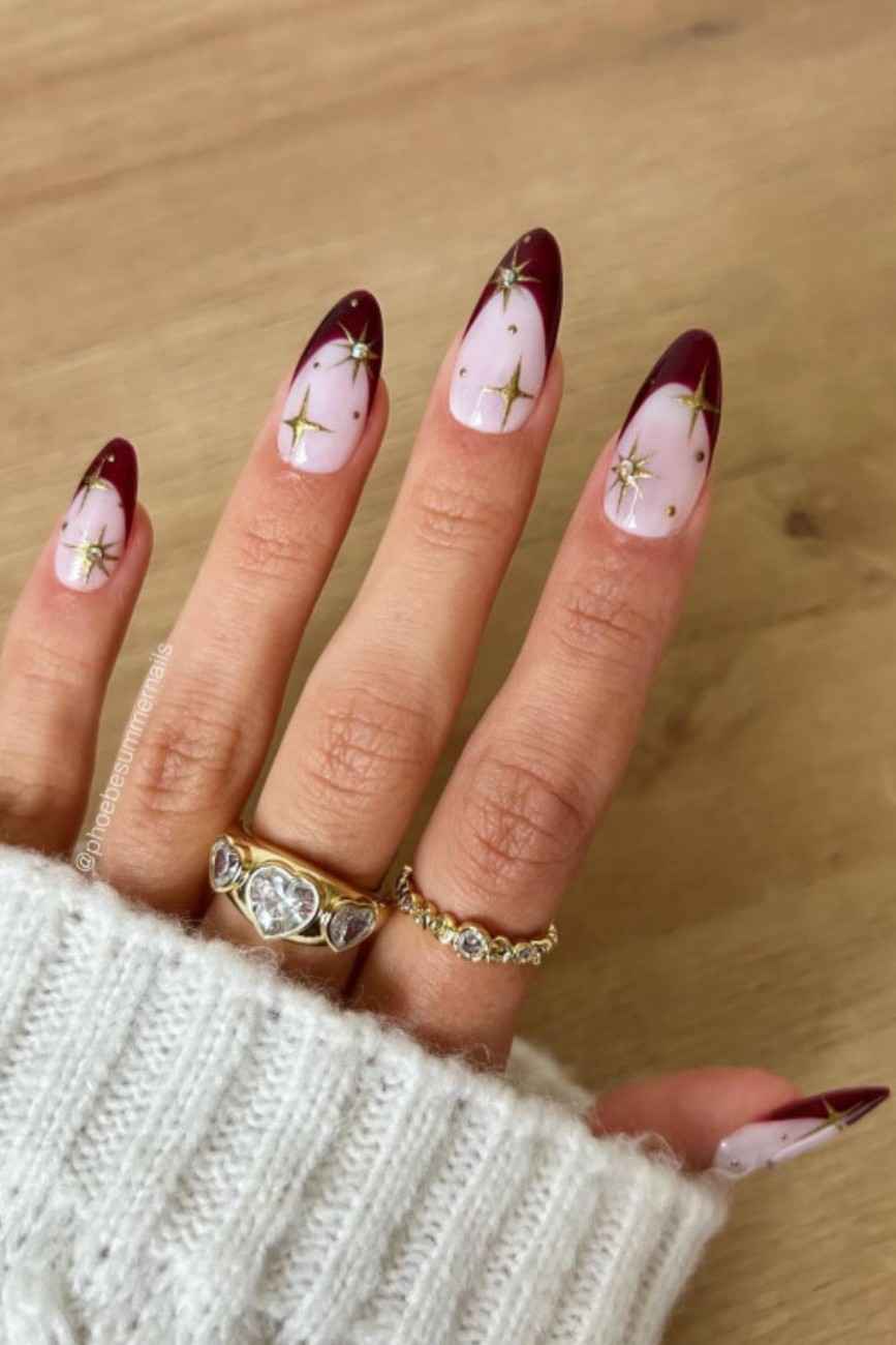 Red nails with starry night accents and almond shape