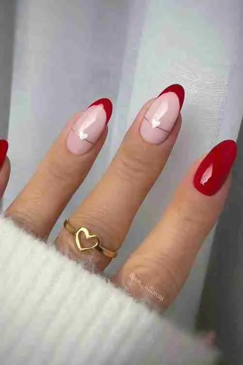 Red nails with heart accents and almond shape