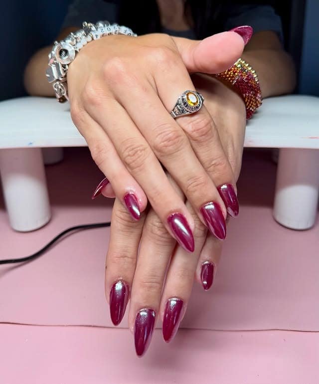 Glossy plum nails with metallic touch, almond shape