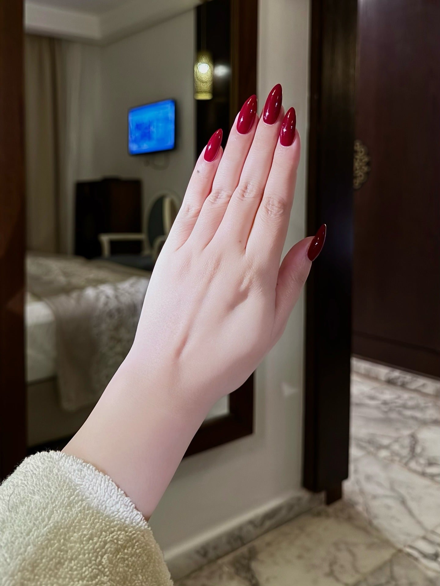 Deep red nails with long almond shape, glossy finish
