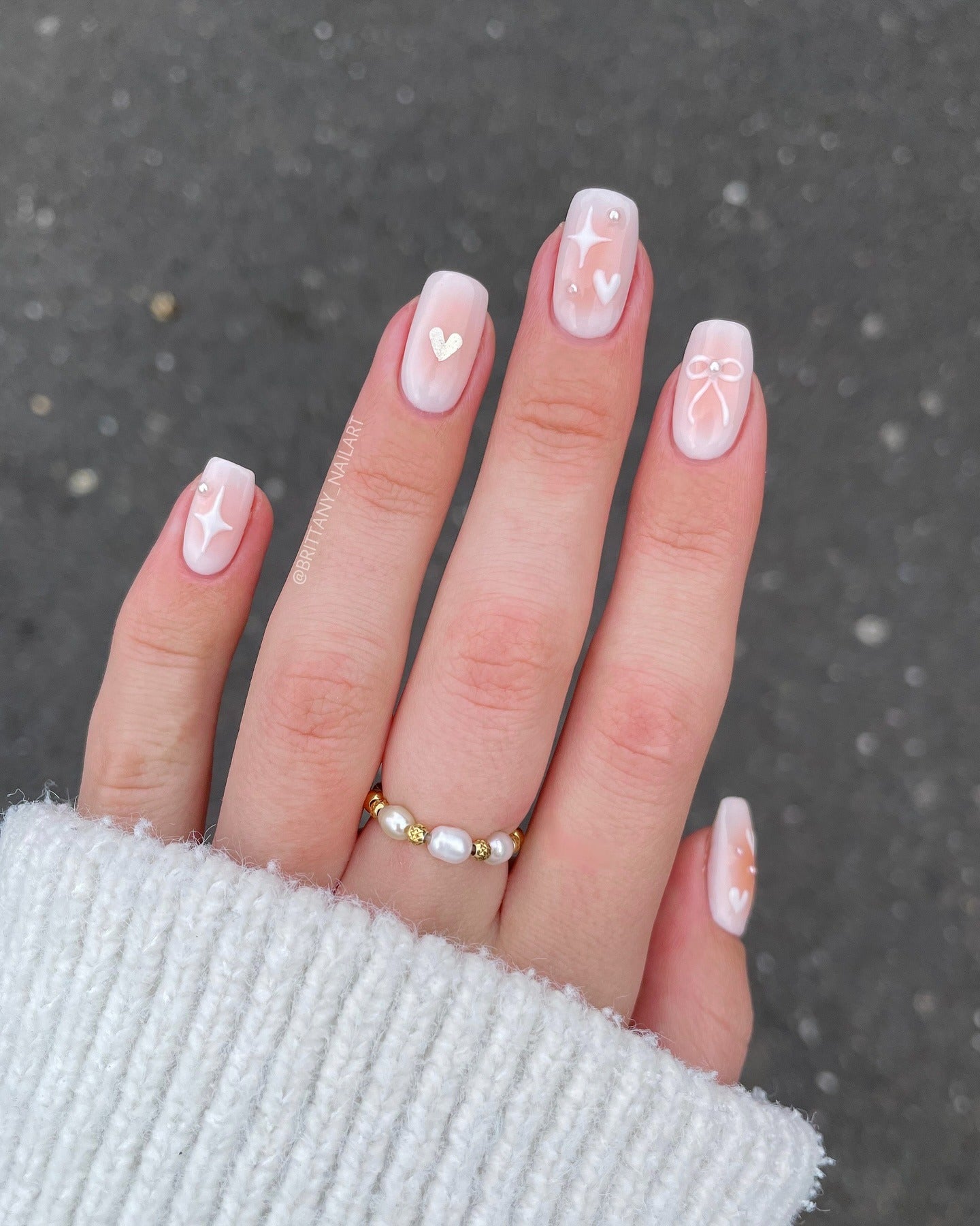 Short square nails with heart and bow nail art on pastel base