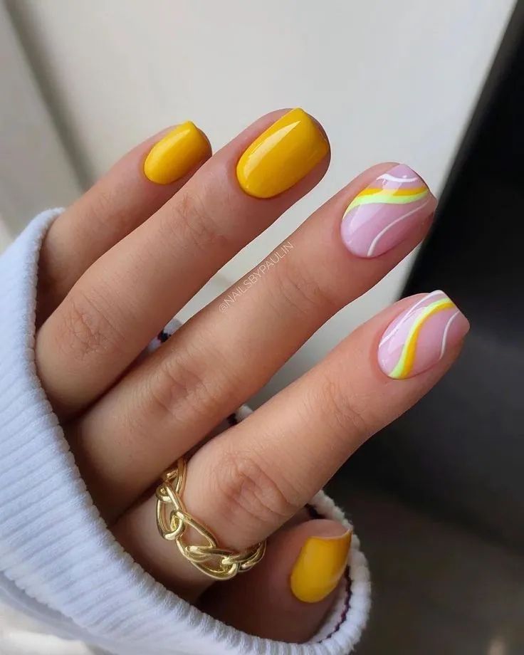 Short square nails with yellow polish and pastel swirl accents