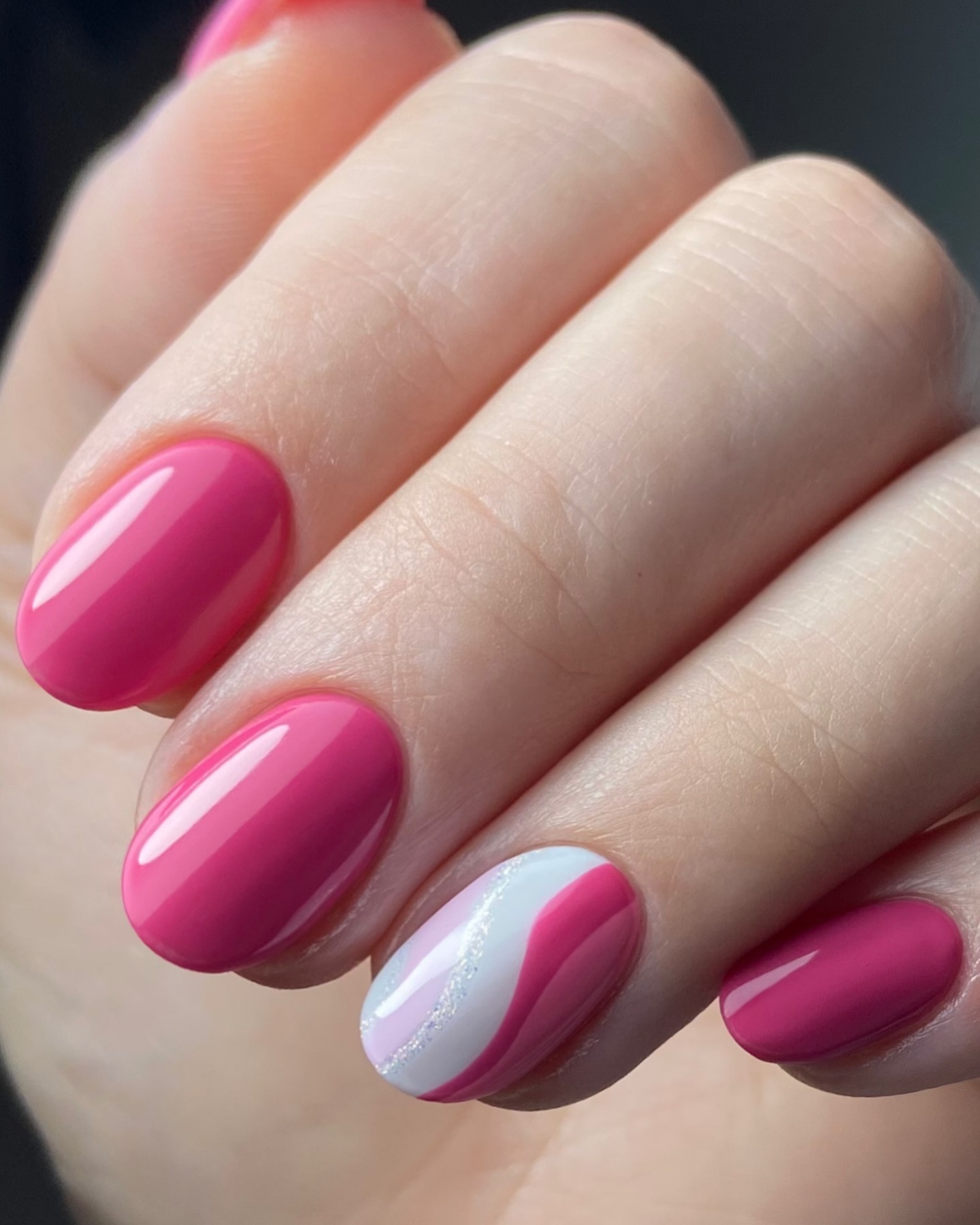 Short oval nails with pink polish and wave accent