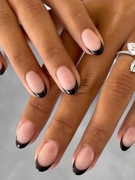 Black French tip nails with nude base, modern elegance, Pinterest chic nails.